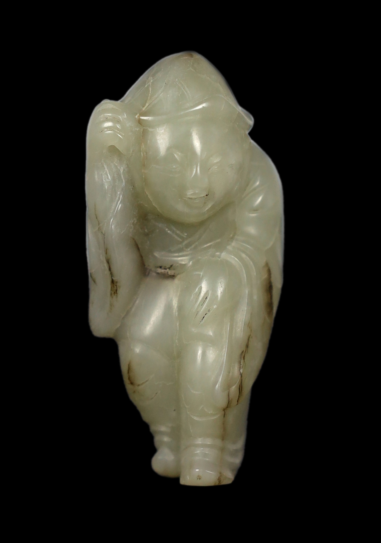 A Chinese white jade figure of a boy wearing a hat and long coat, Ming dynasty